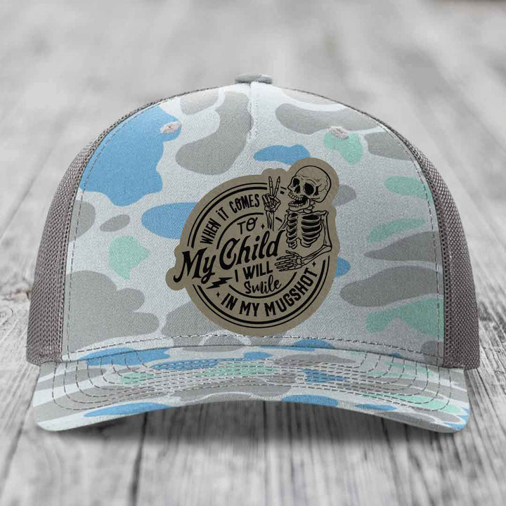 Camouflage trucker hat with a skeleton patch reading &
