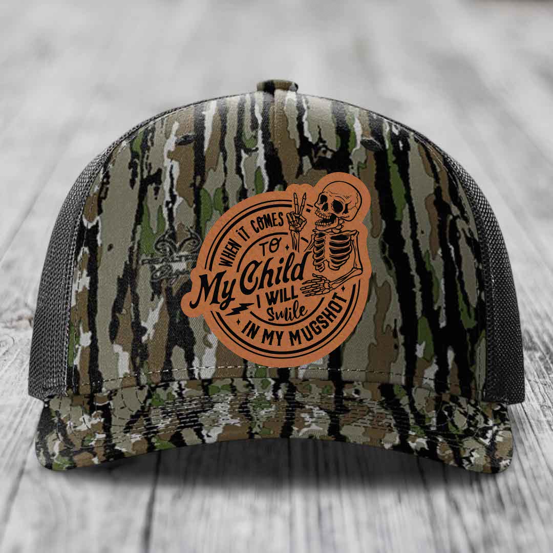 Camouflage trucker hat with orange leather patch featuring skeleton and text &