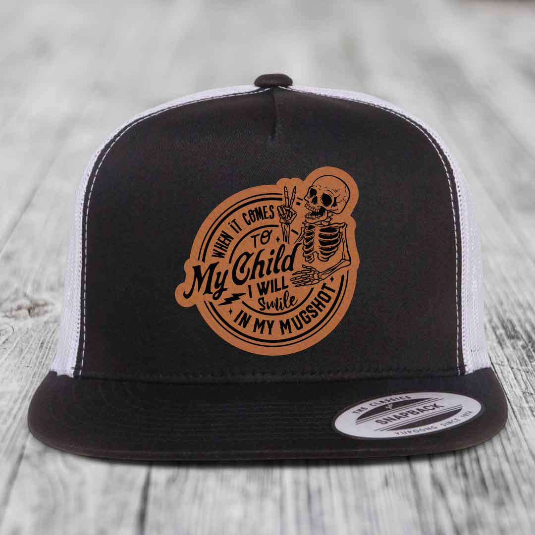 Black and white trucker hat with brown leather patch featuring skeleton holding peace sign and text &