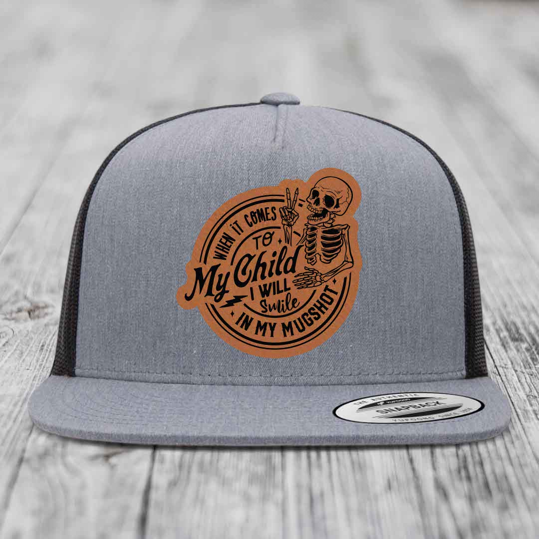 Grey snapback hat with brown leather patch featuring skeleton holding peace sign and text &