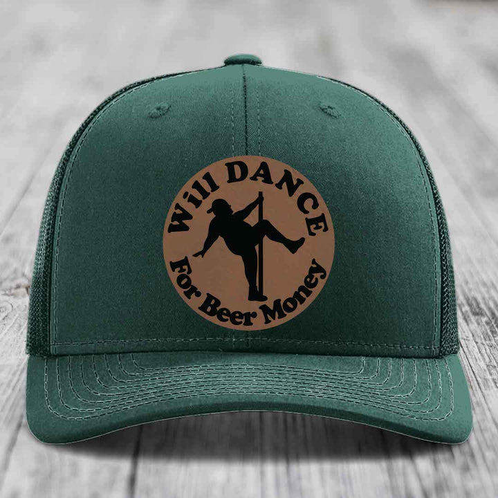 Green trucker hat with brown circular patch showing silhouette of person pole dancing and text &