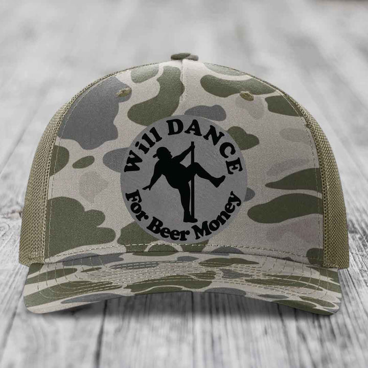 Camouflage trucker hat with circular patch showing silhouette dancing on pole and text &