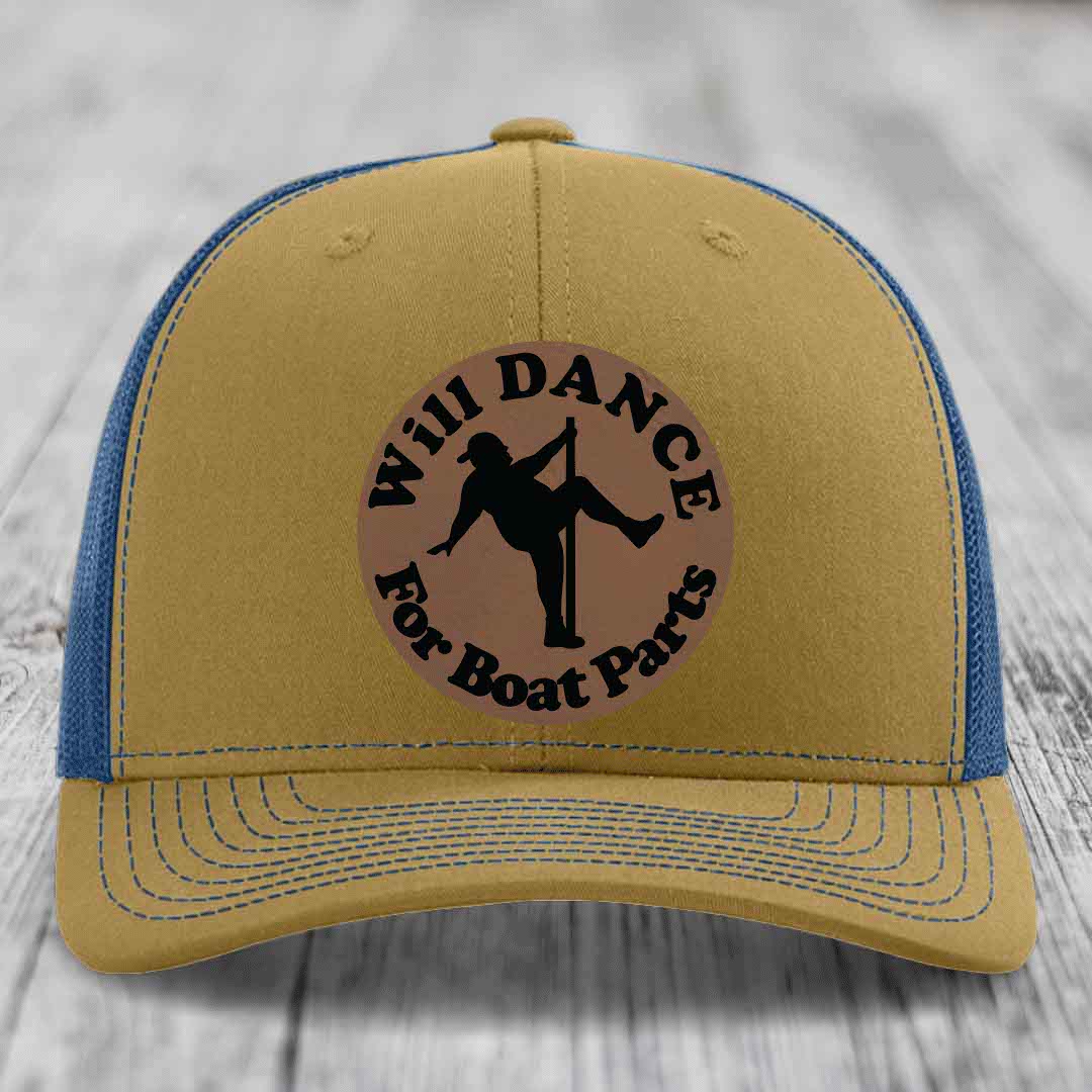 Tan trucker hat with blue mesh back and brim, featuring a circular brown leather patch with black text and pole dancer silhouette.