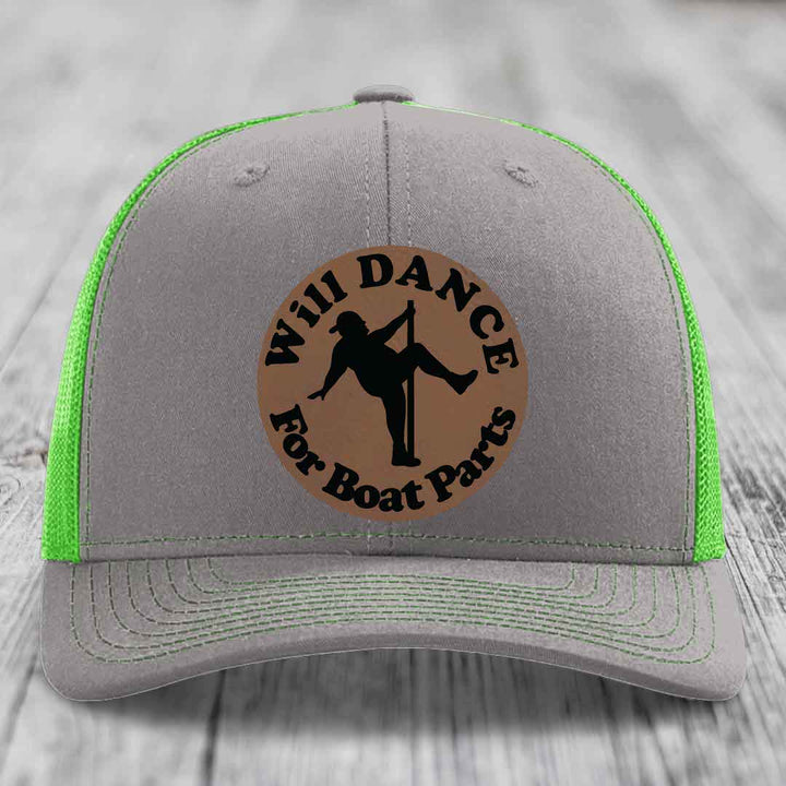 Grey trucker hat with neon green mesh and stitching, featuring a brown circular leather patch with black text and pole dancer silhouette.