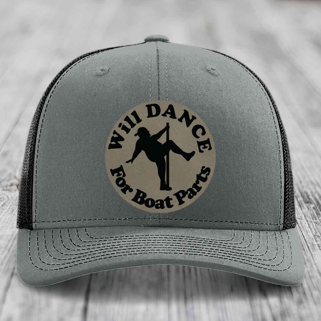 Grey trucker hat with black mesh back and a circular beige patch that reads &