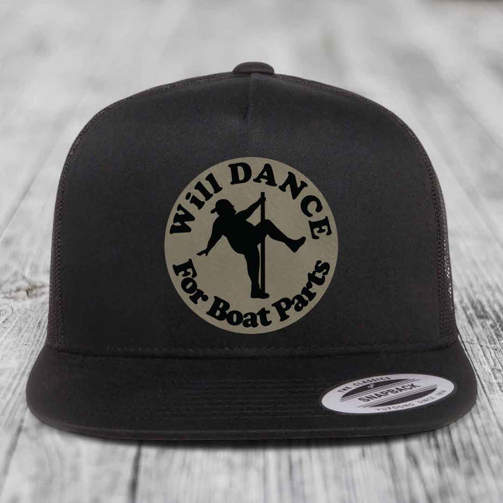 Black snapback hat with circular beige patch showing silhouette of person pole dancing and text &