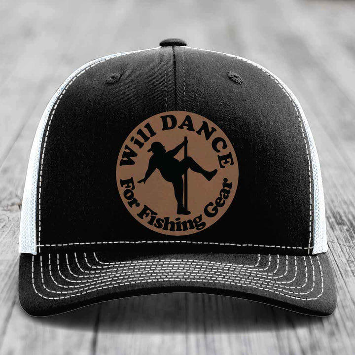 Black trucker hat with white mesh back and stitching, featuring a circular brown leather patch with &