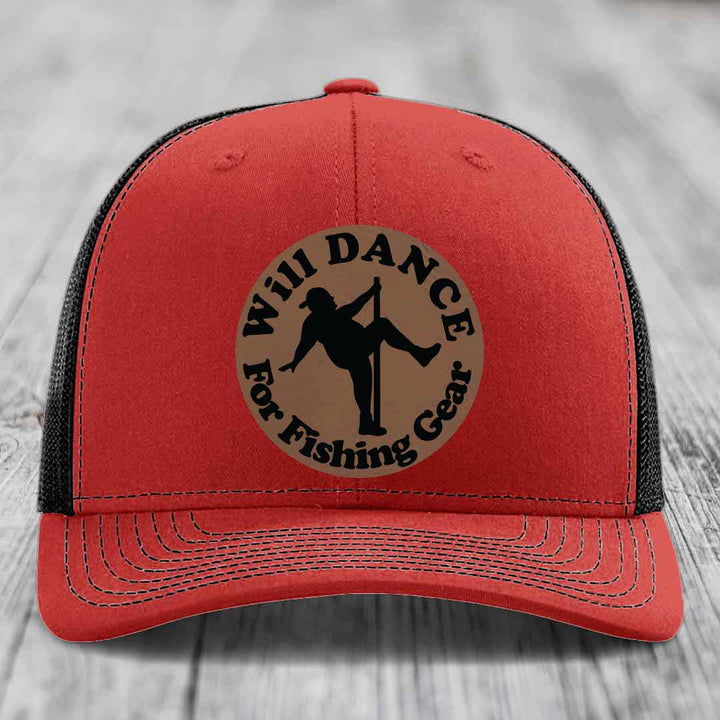 Red trucker hat with black mesh back and a circular brown leather patch that reads &