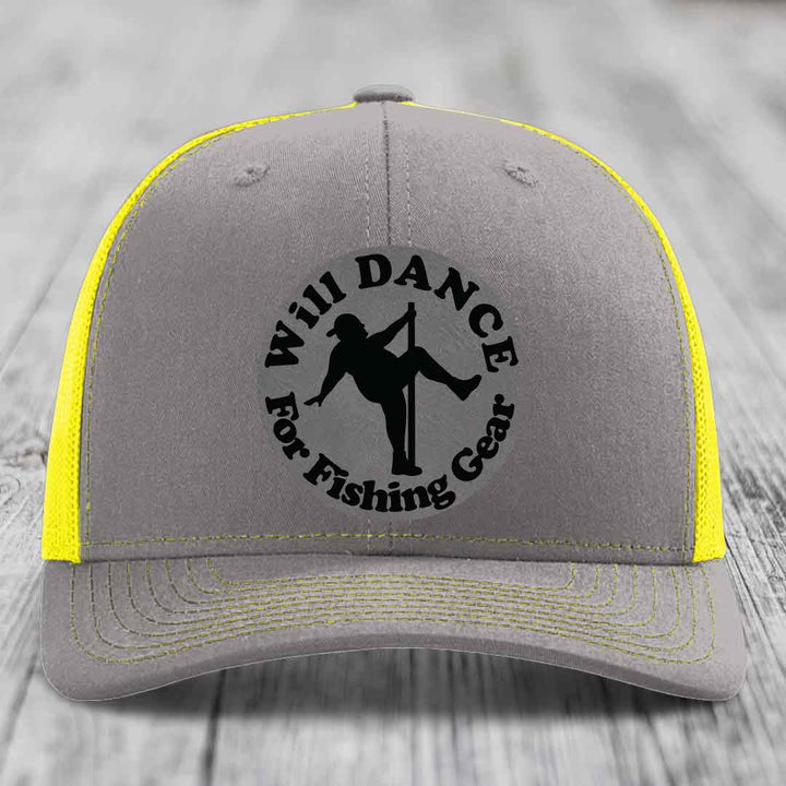 Grey trucker hat with yellow mesh and stitching, featuring a black circular patch that says &