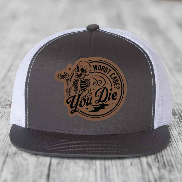 Grey and white trucker hat with a brown leather patch featuring a skeleton and the text &