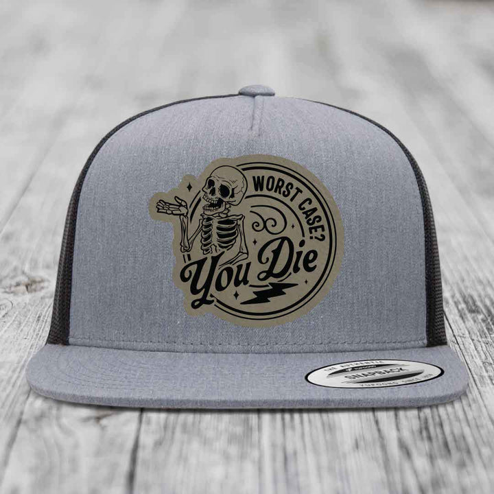 Grey trucker hat with black mesh back and a circular patch featuring a skeleton and the text &