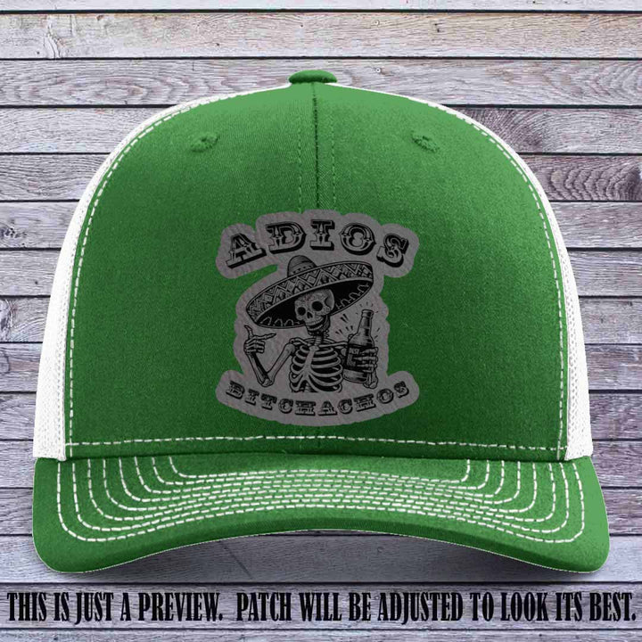 Grey leather patch on Kelly to White Richardson 112 trucker hat featuring “Adios Bitchachos” skeleton design.