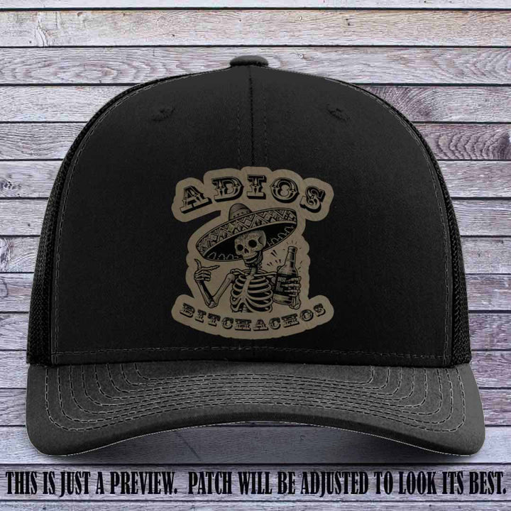 Light brown leather patch on Black Richardson 112 trucker hat featuring “Adios Bitchachos” skeleton design.
