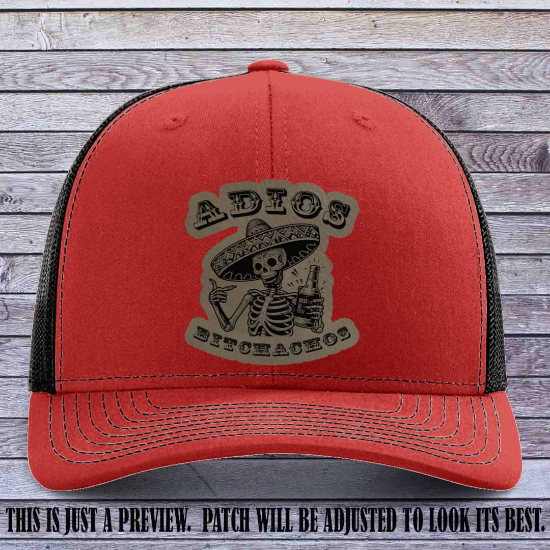 Light brown leather patch on Red to Black Richardson 112 trucker hat featuring “Adios Bitchachos” skeleton design.