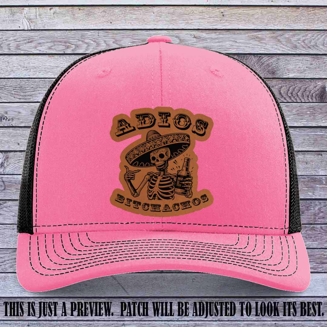 Rawhide leather patch on Hot Pink to Black Richardson 112 trucker hat featuring “Adios Bitchachos” skeleton design.