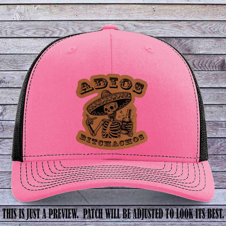 Rawhide leather patch on Hot Pink to Black Richardson 112 trucker hat featuring “Adios Bitchachos” skeleton design.
