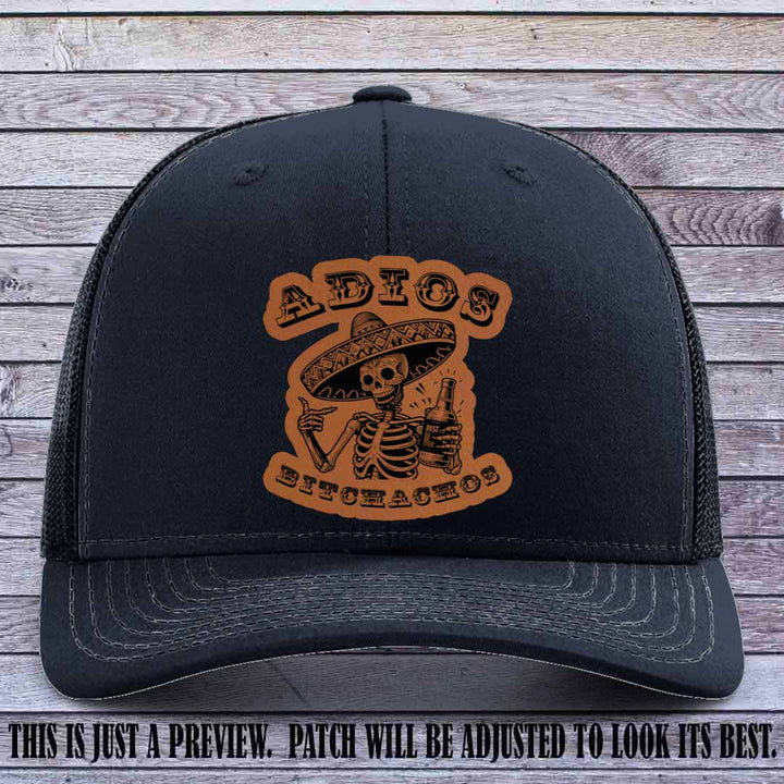 Rawhide leather patch on Navy Richardson 112 trucker hat featuring “Adios Bitchachos” skeleton design.