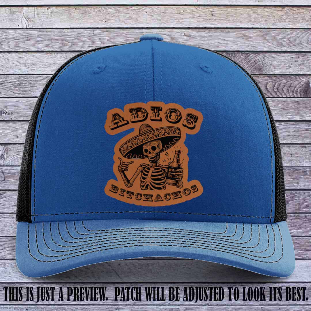 Rawhide leather patch on Royal to Black Richardson 112 trucker hat featuring “Adios Bitchachos” skeleton design.