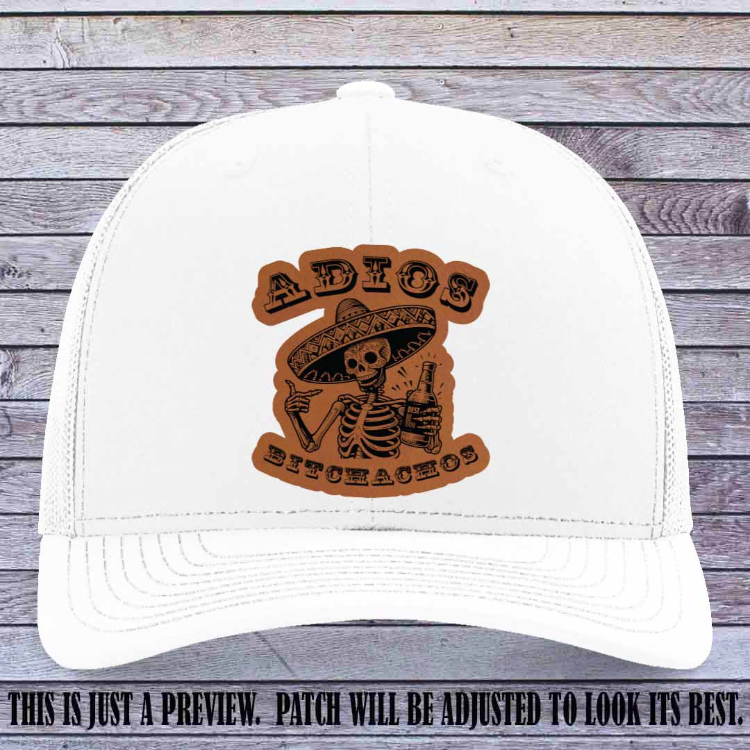 Rawhide leather patch on White Richardson 112 trucker hat featuring “Adios Bitchachos” skeleton design.