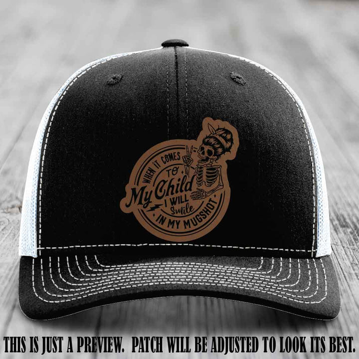 Richardson 112 custom trucker hat with dark brown to black patch and 'My Child Mugshot' leather patch on black to white hat