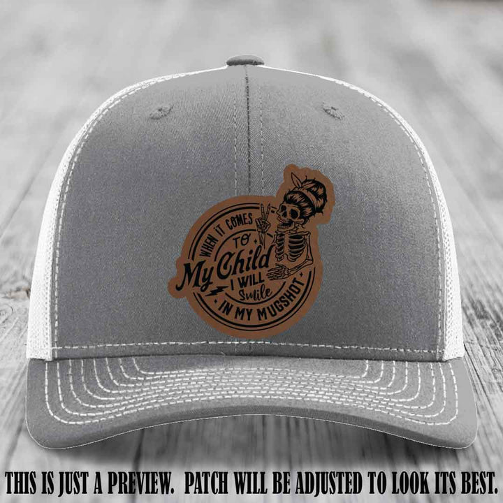 Richardson 112 custom trucker hat with dark brown to black patch and 'My Child Mugshot' leather patch on heather grey to white hat