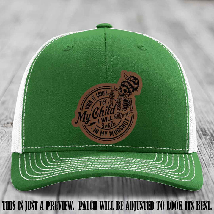 Richardson 112 custom trucker hat with dark brown to black patch and 'My Child Mugshot' leather patch on kelly to white hat
