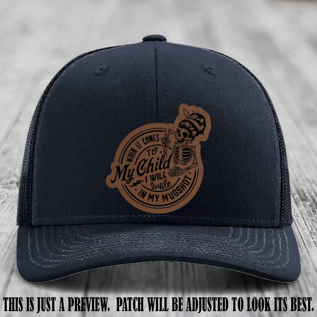 Richardson 112 custom trucker hat with dark brown to black patch and 'My Child Mugshot' leather patch on navy hat