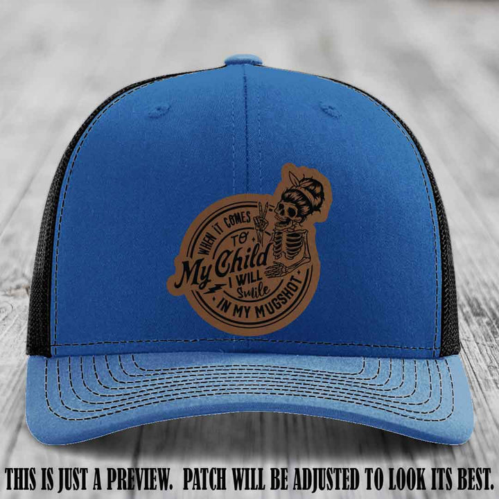 Richardson 112 custom trucker hat with dark brown to black patch and 'My Child Mugshot' leather patch on royal to black hat