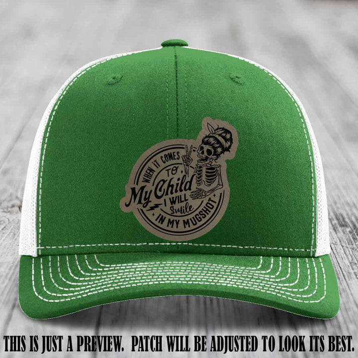 Richardson 112 custom trucker hat with light brown to black patch and 'My Child Mugshot' leather patch on kelly to white hat