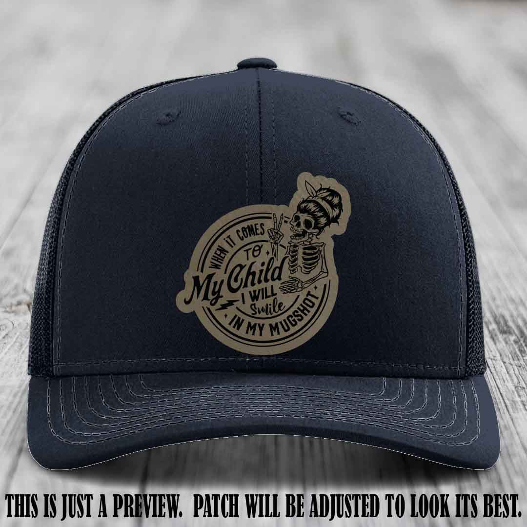 Richardson 112 custom trucker hat with light brown to black patch and 'My Child Mugshot' leather patch on navy hat